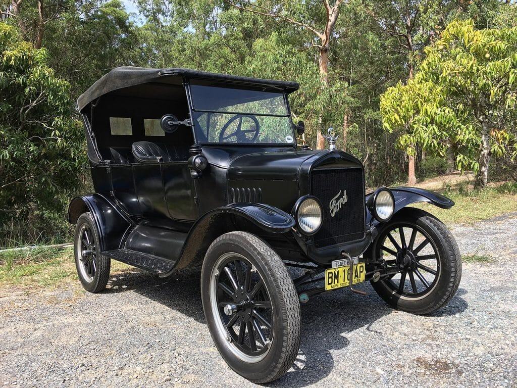 1925 Ford Model T touring car parked in a natural setting, highlighting its vintage design and classic features, relevant to antique vehicle repair and restoration services.
