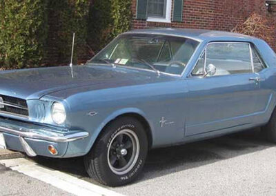 Classic 1965 Ford Mustang coupe in blue, parked on the street, showcasing Wilson Auto Repair's restoration expertise in classic vehicles.
