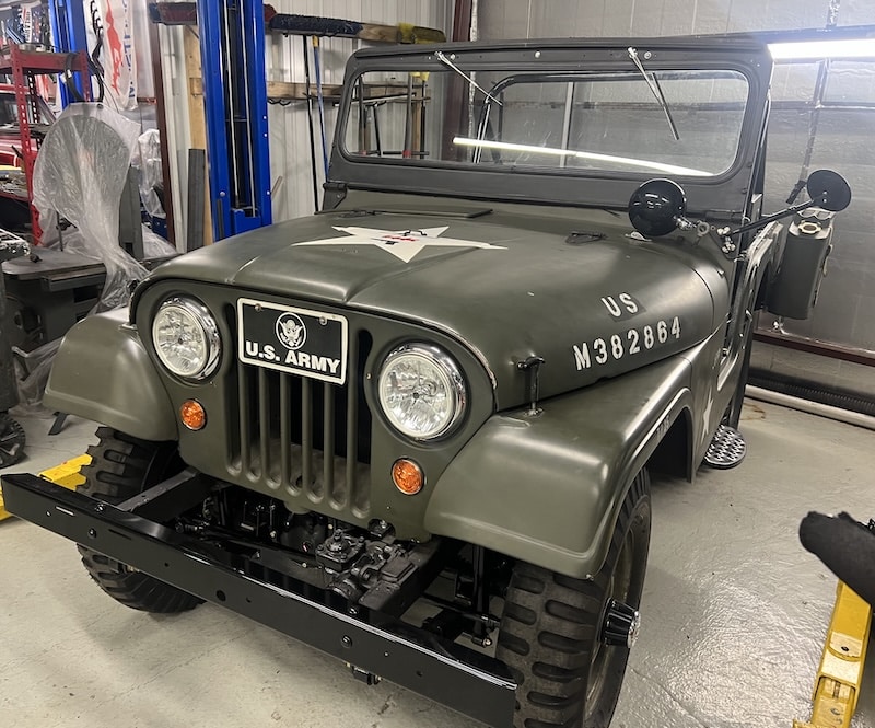 Restored US Army Jeep Restored U.S. Army Jeep in a workshop, showcasing expert craftsmanship and historical authenticity for antique vehicle repair.